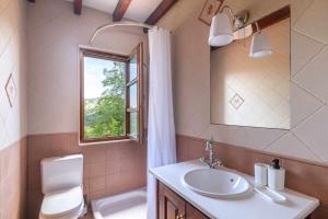 une salle de bain avec un lavabo et des toilettes et une fenêtre dans l'établissement Vivienda Vacacional La Cortina, à Meré 34 autres photos