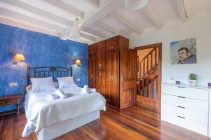 a bedroom with a large bed and a staircase at Vivienda Vacacional La Cortina in Meré