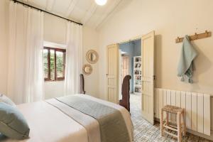 una camera da letto con un letto bianco e una finestra di Garriguella- Roses – Pool Costa Brava House a Garriguella Altre 18 foto