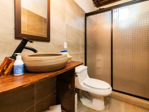 a bathroom with a toilet and a glass shower at OYO Posada Del Pescador in Cabo San Lucas