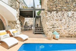 un patio esterno con piscina e parete in pietra di Garriguella- Roses – Pool Costa Brava House a Garriguella