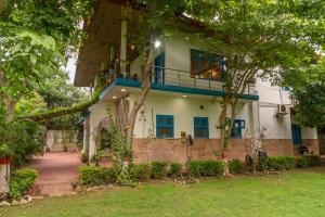 a house with a balcony on top of it at Sukoon Farm Stay in New Delhi