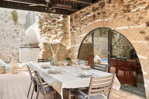 una sala da pranzo con tavolo e sedie bianchi di Garriguella- Roses – Pool Costa Brava House a Garriguella