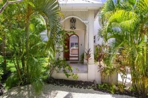 a white house with palm trees in front of it at Rock Ridge by Barbados Sothebys International Realty in Saint Peter
