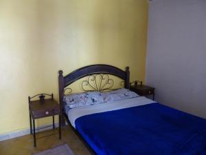 1 dormitorio con 1 cama y 2 mesitas de noche en Auberge Chez Hassan, en Imsouane