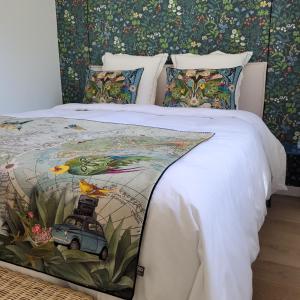 a bed with a white comforter with a car on it at LA VILLA MARIE in Richebourg