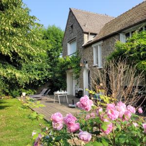 a garden with pink roses in front of a house at LA VILLA MARIE in Richebourg