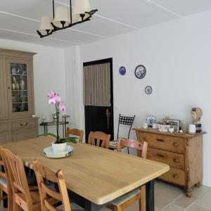 cocina y comedor con mesa de madera y sillas en LA VILLA MARIE, en Richebourg
