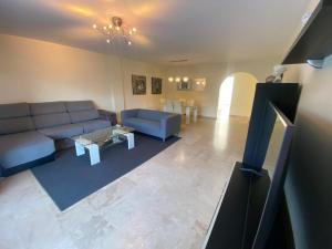 a living room with a blue couch and a table at Jardines de Banús Apartments in Marbella
