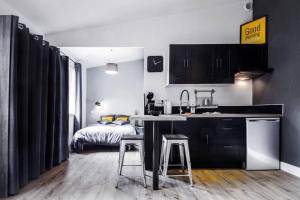 a kitchen with a sink and a bed in a room at Coeur Toulouse St Cyprien T1 bis type Loft in Toulouse