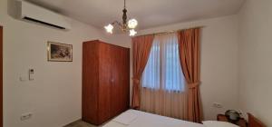 a bedroom with a bed and a dresser and a window at Apartments Stengl in Rab