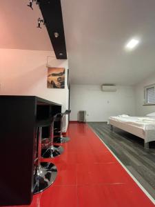 Habitación con cama y suelo rojo. en MORIC APARTMENTS 2, en Stankovci
