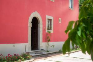 un bâtiment rouge et blanc avec une porte dans l'établissement Podere Belvedere Tuscany, à Pontassieve