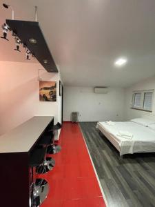 1 dormitorio con 1 cama y suelo rojo en MORIC APARTMENTS 2, en Stankovci