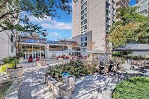 un patio con mesas y sombrillas en un edificio en Elegant Condo with Gorgeous Views at Crystal City en Arlington