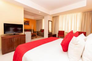 - une chambre dotée d'un grand lit avec des oreillers rouges et blancs dans l'établissement Hotel Faranda Express Puerta del Sol Porlamar, à Porlamar