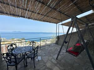 - une terrasse couverte avec une balançoire, une table et des chaises dans l'établissement Hotel Vila "Oda E Miqve", à Vlorë
