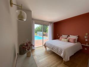 sypialnia z łóżkiem i dużym oknem w obiekcie La Musardise Guest House w mieście Berson