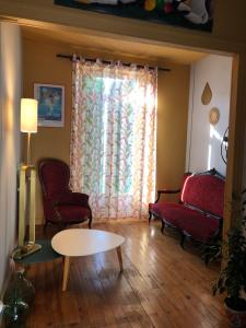 a living room with two chairs and a table and a window at Chambres d'Hôtes A Buglose in Saint-Vincent-de-Paul