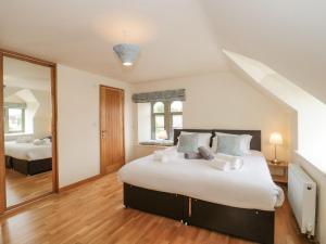 a bedroom with a large bed and a mirror at The Old Schoolrooms in Radstock