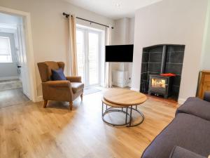 a living room with a couch and a table and a fireplace at 1 Golf Links Cottages in Northwich