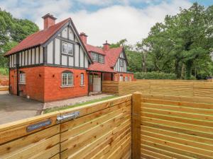 a wooden fence in front of a house at 1 Golf Links Cottages in Northwich