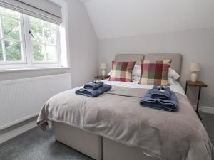 a bedroom with a bed with two blue towels on it at 1 Golf Links Cottages in Northwich