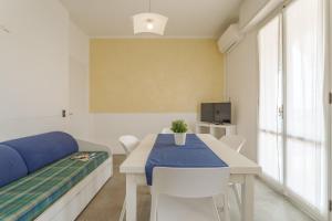 Habitación con mesa, cama y TV. en Residence Mizar, en Pietra Ligure