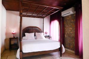 een slaapkamer met een hemelbed met witte lakens bij La Violeta HOTEL SPA & CHILL OUT in Castelltersol