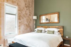 um quarto com uma cama com um espelho e uma janela em Artistic Loft Near NYC's Buzz - Photo-Ready Stay em Edgewater