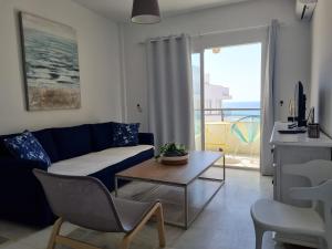 a living room with a blue couch and a table at Sea Village Real in Estepona