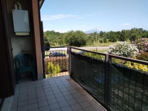 einen Balkon mit einem Stuhl und Straßenblick in der Unterkunft Flat Garda in Cavalcaselle