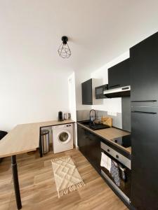 a kitchen with a table and a washing machine at Le Mayda - Parking Privé Gratuit in Marseille