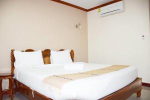 een slaapkamer met een wit bed met witte kussens bij NP Residence in Nakhon Phanom