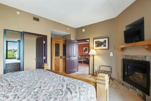 ein Schlafzimmer mit einem Bett und einem Kamin in der Unterkunft Chula Vista Condo 2408 in Wisconsin Dells