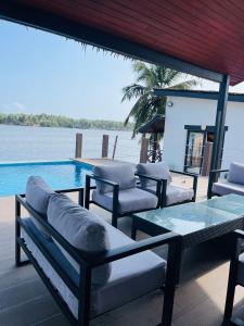 a patio with chairs and a table and a pool at Villa Assinie Bord de Lagune in Assinie