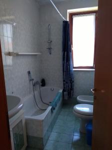 ein Badezimmer mit einer Badewanne, einem WC und einem Waschbecken in der Unterkunft Flat Garda in Cavalcaselle