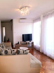 ein Wohnzimmer mit einem Sofa und einem Flachbild-TV in der Unterkunft Elizabeth apartment 2 bedroom sityBudva in Budva