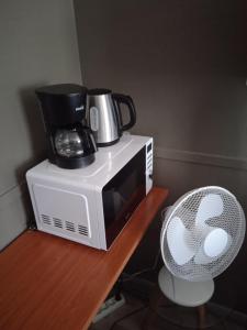 a coffee maker on top of a microwave at Ellivuori. Ellin Pooli 4 in Sastamala