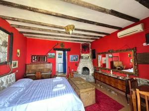 - une chambre avec des murs rouges, un lit et une cheminée dans l'établissement Hotel Vila "Oda E Miqve", à Vlorë
