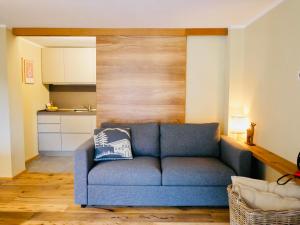 un divano blu in soggiorno con cucina di Nuovo Appartamento moderno a Cogne a Cogne