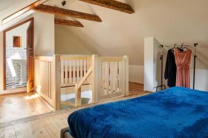 a bedroom with a blue bed and wooden floors at Kristian - House and Garden in Český Krumlov