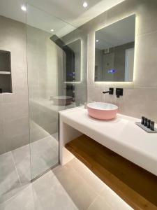 a bathroom with a sink and a glass shower at Absolute Water Front properties by Blue Waters Mykonos in Ornos +28 photos