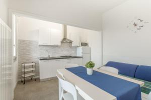 una cucina e una sala da pranzo con tavolo e sedie blu di Residence Mizar a Pietra Ligure