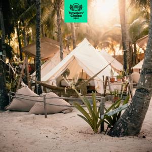 a group of tents on a beach with palm trees at Cinco Tulum in Tulum