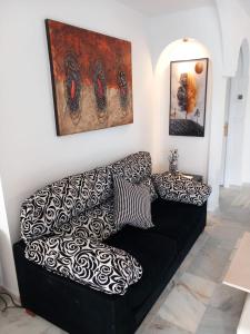 a black couch with pillows in a living room at Duquesa Beach in Torrevieja