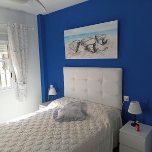 a blue bedroom with a bed and a blue wall at Duquesa Beach in Torrevieja