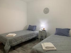 a room with two beds and a table with a lamp at Casa 1-Quinta dos Penedos in Portalegre