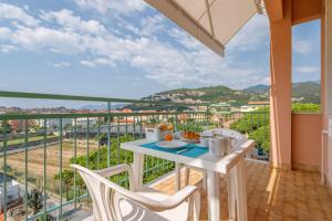 una mesa blanca y sillas en un balcón con vistas en Residence Mizar, en Pietra Ligure