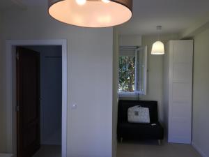 um quarto com uma cadeira preta e uma grande iluminação em Casa con Jardín con 2 alojamientos, con jardines no compartidos y aparcamiento privado em Noja